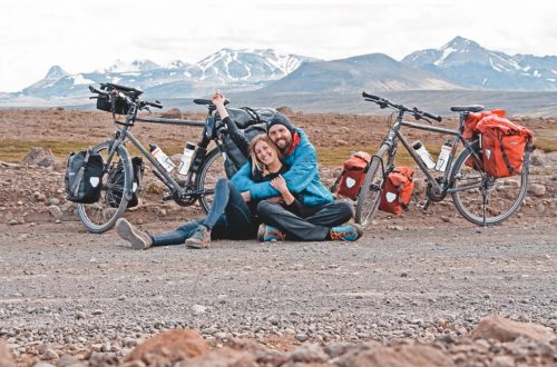 Franziska und Felix mit ihren Fahrrädern im isländischen Hochland. Im Hintergrund Bergkulisse